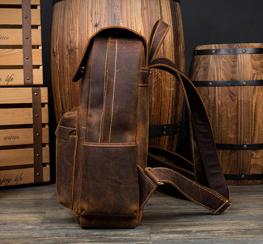 Men’s Cowhide Leather Backpack – Retro Travel Rucksack in Deep Oak & Saddlewood. Next to wooden barrels.